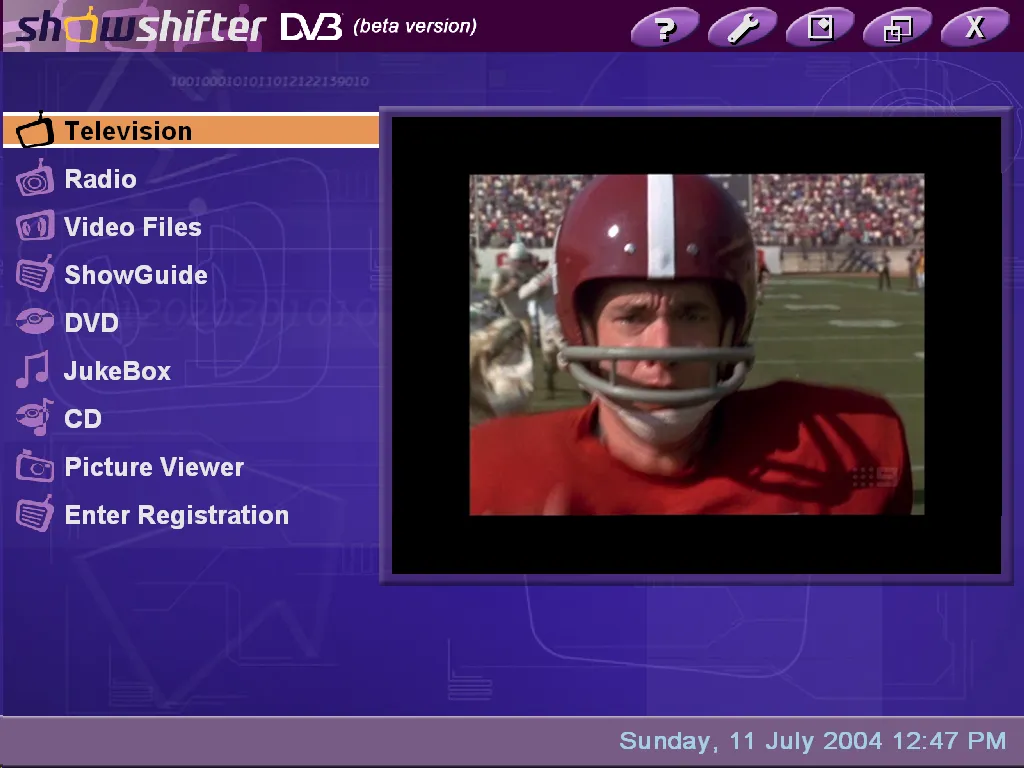 The ShowShifter DVB window at 1024 by 768. A purple menu down the left lists Television, Radio, Video Files, ShowGuide, DVD, JukeBox, CD, Picture Viewer and Enter Registration, with Television highlighted in orange. A television picture of an American football player in a red helmet plays in a framed panel on the right. The title bar reads showshifter DVB, beta version, and the status bar reads Sunday, 11 July 2004 12:47 PM